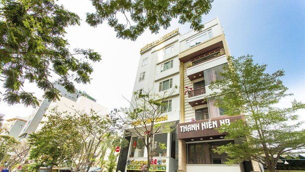 A multi-story hotel with balconies, a visible restaurant, and a sign for a hotel named "THANH HIEN HB". - OYO 1067 Phuc Long Hotel (Da Nang)