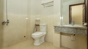 A bathroom with a toilet, a sink, a mirror, and a shower. - OYO 1067 Phuc Long Hotel (Da Nang)