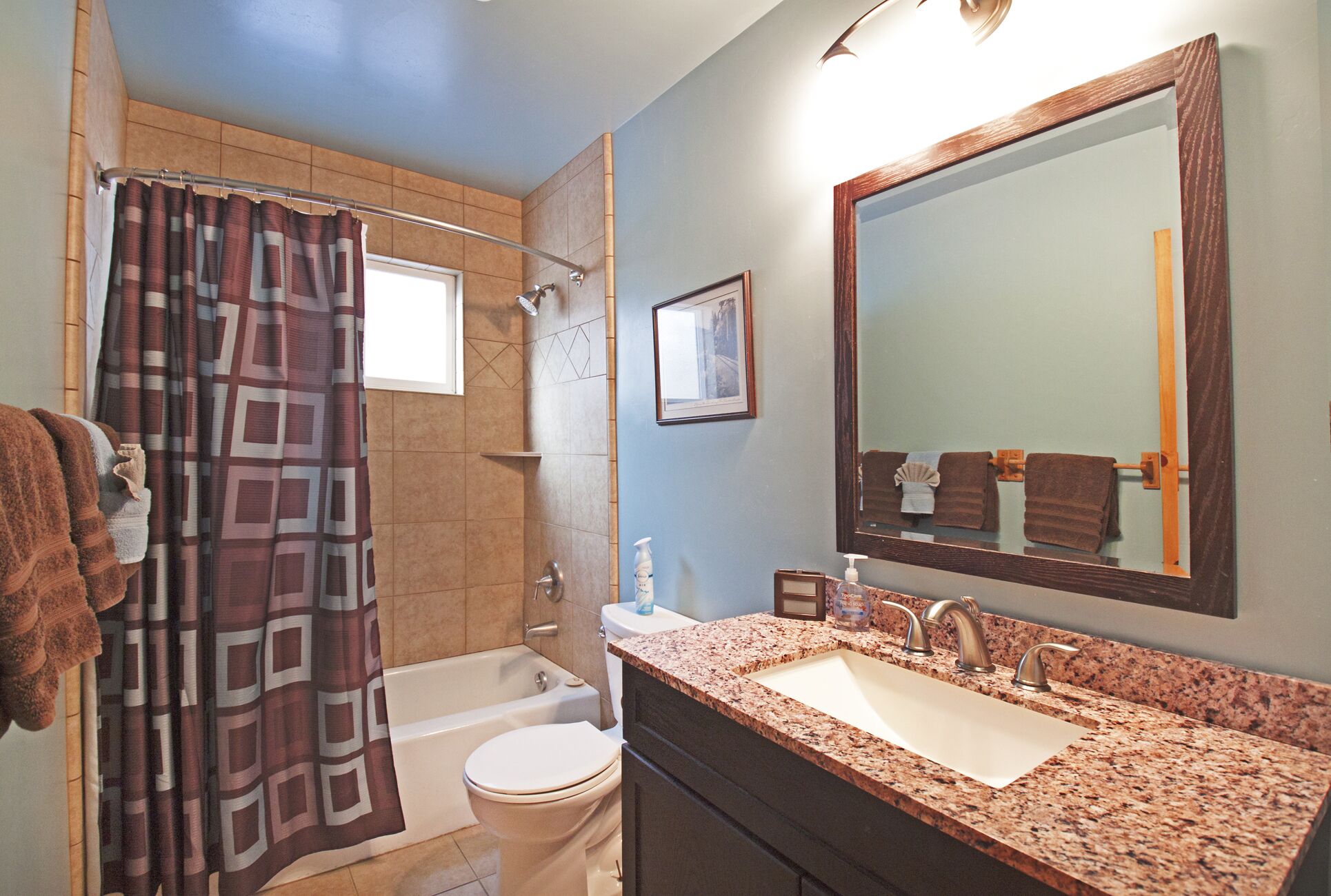 Une salle de bain équipée d’une baignoire, de toilettes, d’un lavabo et d’un rideau de douche.