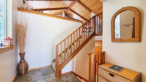A wooden staircase with a stone floor leading to an upper level. - Chalet Lani - HOT TUB - 3 bedroom, 2 bath - Quiet Location! (Homewood)