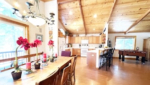 A spacious kitchen with wooden cabinets, a dining area with a wooden table and chairs, and a pool table. - Chalet Lani - HOT TUB - 3 bedroom, 2 bath - Quiet Location! (Homewood)