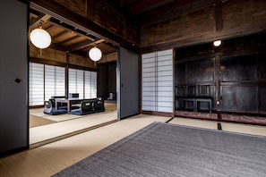 Ett traditionellt japanskt rum med tatamimattor på golvet, skjutdörrar och ett lågt träpanelat tak.