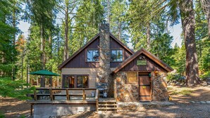 A cabin with a stone chimney, wooden deck, and a sign indicating a 150 ft. elevation. - Quandt Cabin - Old Tahoe Cabin - WALK TO LAKE! (Tahoe City)