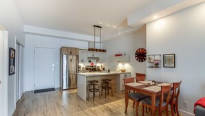 Una cocina moderna con una isla central, electrodomésticos de acero inoxidable y taburetes de madera.