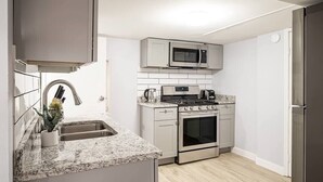 Una cocina compacta con microondas, estufa, horno y lavaplatos.