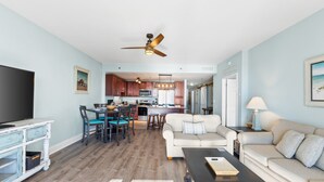 A modern living room with a sofa, coffee table, and dining area.