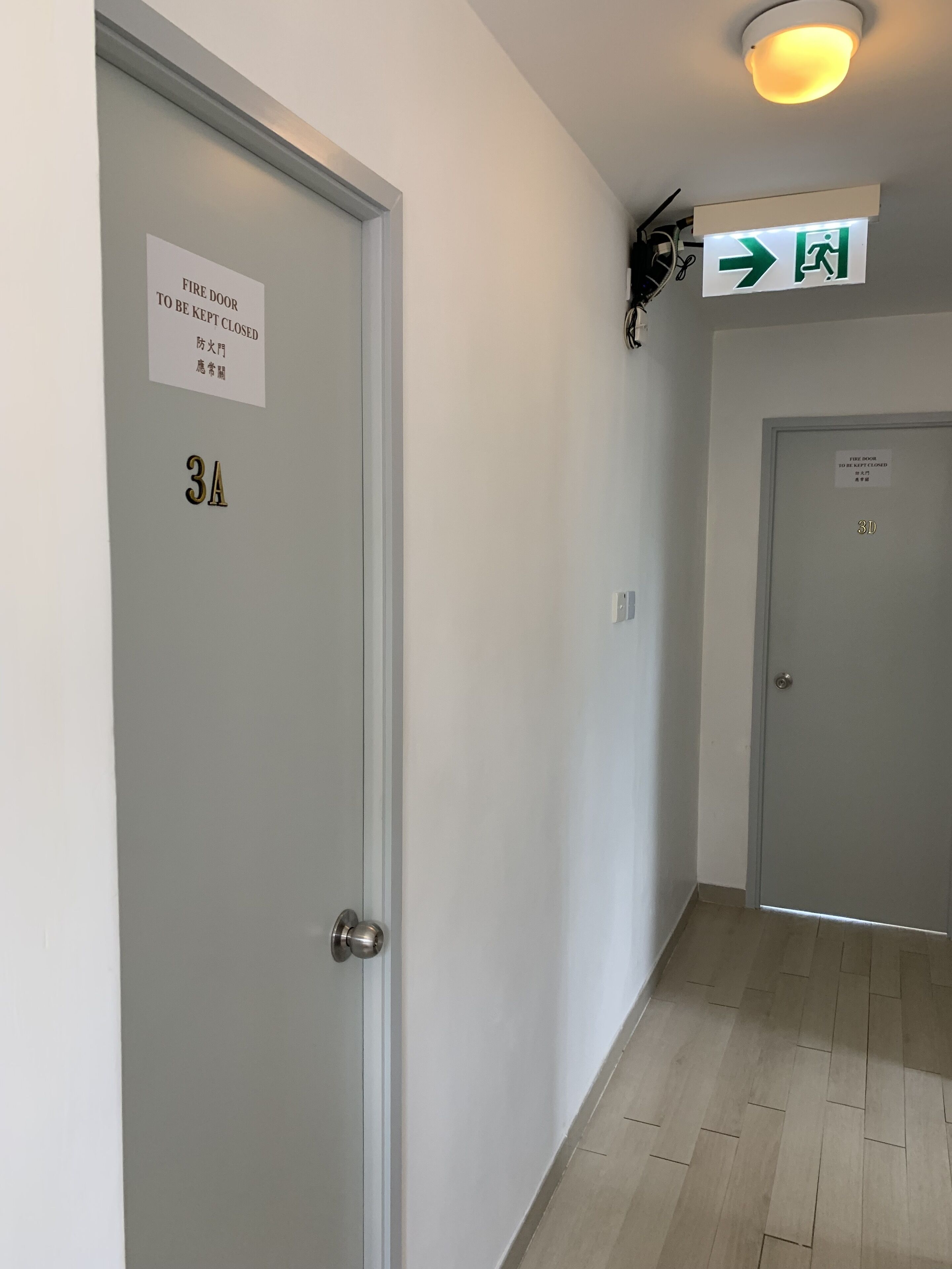 A hallway with a door labeled '3A' and a sign indicating an exit.