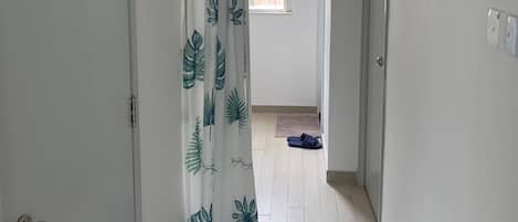A hallway with a fire door, a window with a view, and a door with a sign.