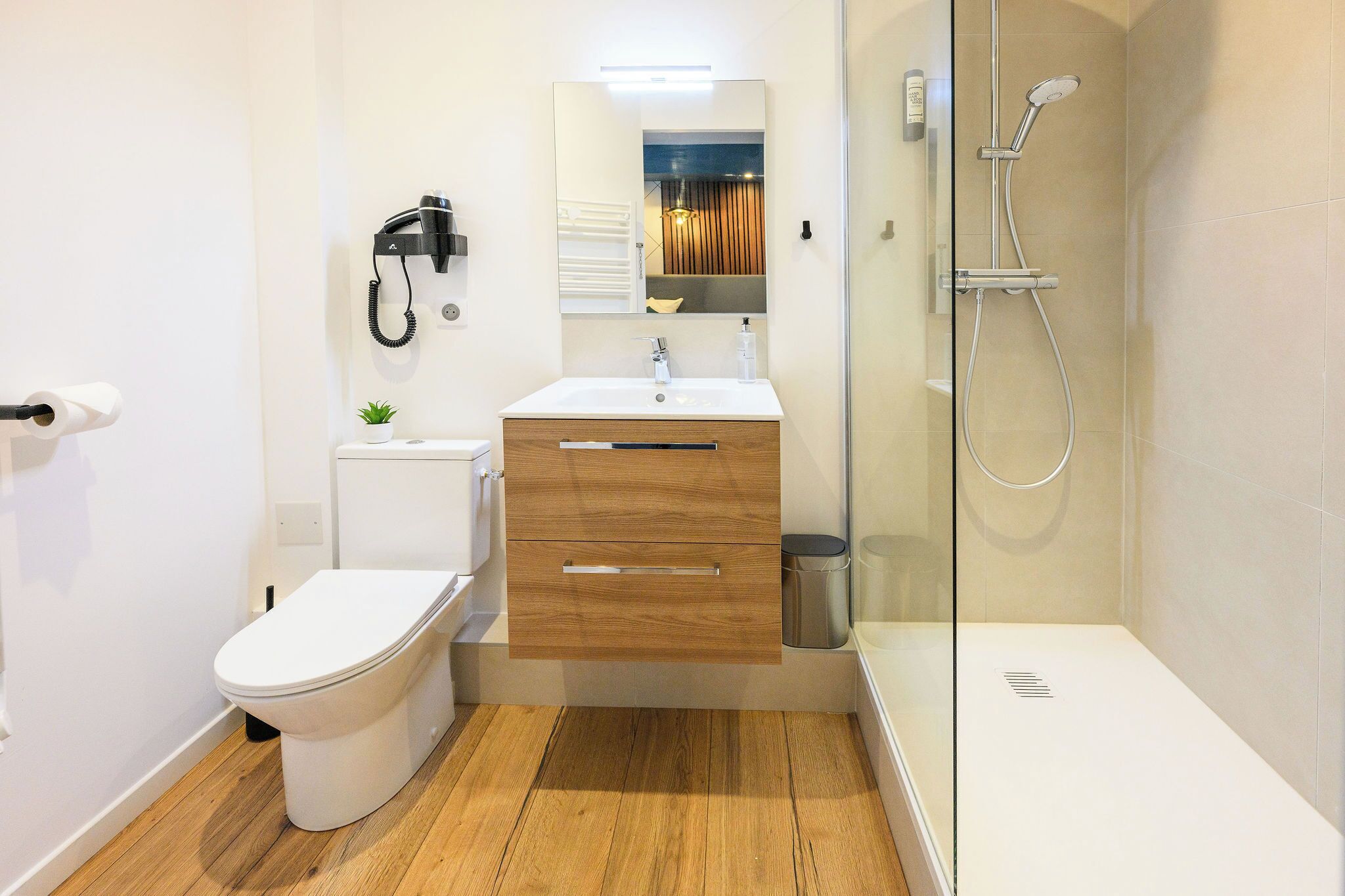 Un baño moderno con inodoro, lavamanos y ducha.