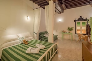 A room with a bed, a chair, a table, and a window with curtains. - Picabon Apartment with AC Balcony (Monterosso al Mare)