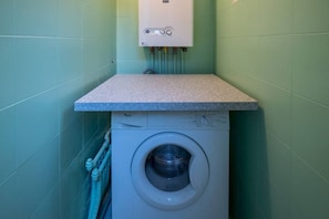 A compact laundry area with a washing machine and a water heater. - Picabon Apartment with AC Balcony (Monterosso al Mare)