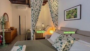A double bed and a double sofa bed in a room with floral curtains, a framed picture on the wall, and a bedside lamp. - Picabon Apartment with AC Balcony (Monterosso al Mare)