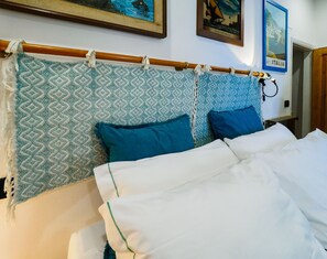 A bed with a patterned headboard, two pillows, and a white blanket.