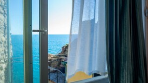 A window with a view of the sea and a stone wall. - Ventu de Ma Sea View Room #3 (Vernazza)