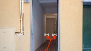 A hallway with a red carpet leading to two rooms labeled R#1 and R#2.