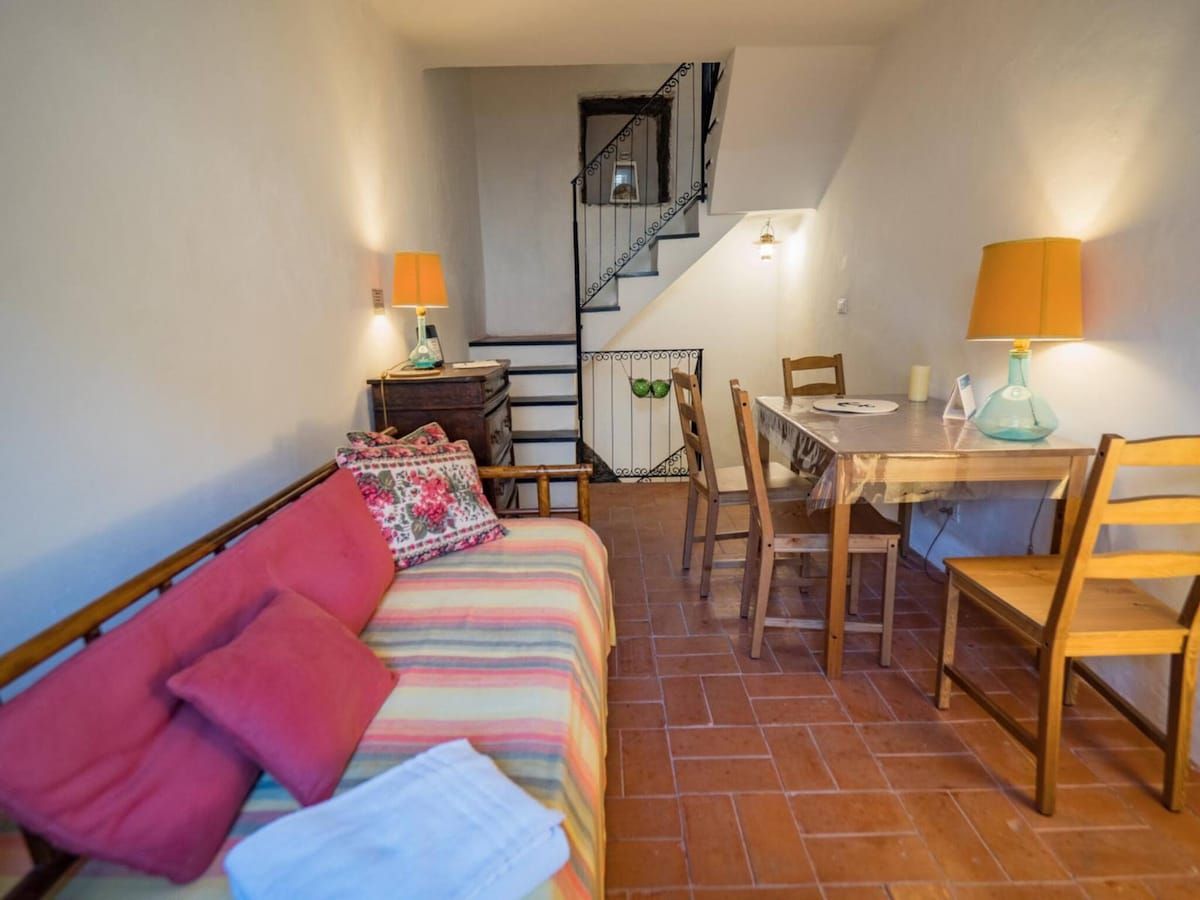 Una camera da letto con un letto, una scrivania e una sedia. Si nota una scala che conduce a un piano superiore.