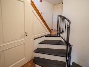 A staircase with black steps and a wooden handrail leading to a white door. - Refilea Historic Sea View Tower, Vernazza (Vernazza)