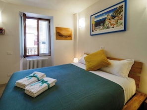 A hotel room with a bed, a window, a painting, and a radiator. - Ventu de Ma First Floor Studio with AC (Vernazza)