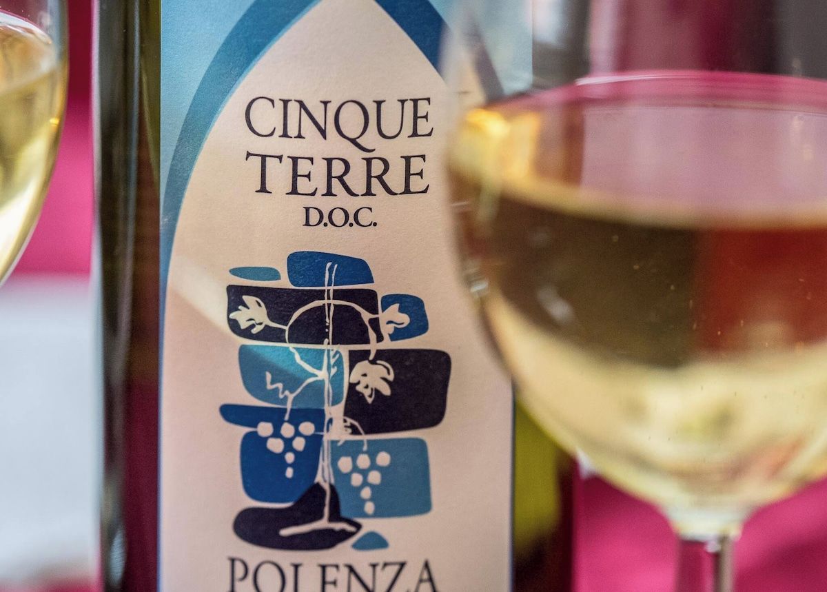 En flaska Cinque Terre DOC-vin med en etikett som föreställer en vinstock och löv.
