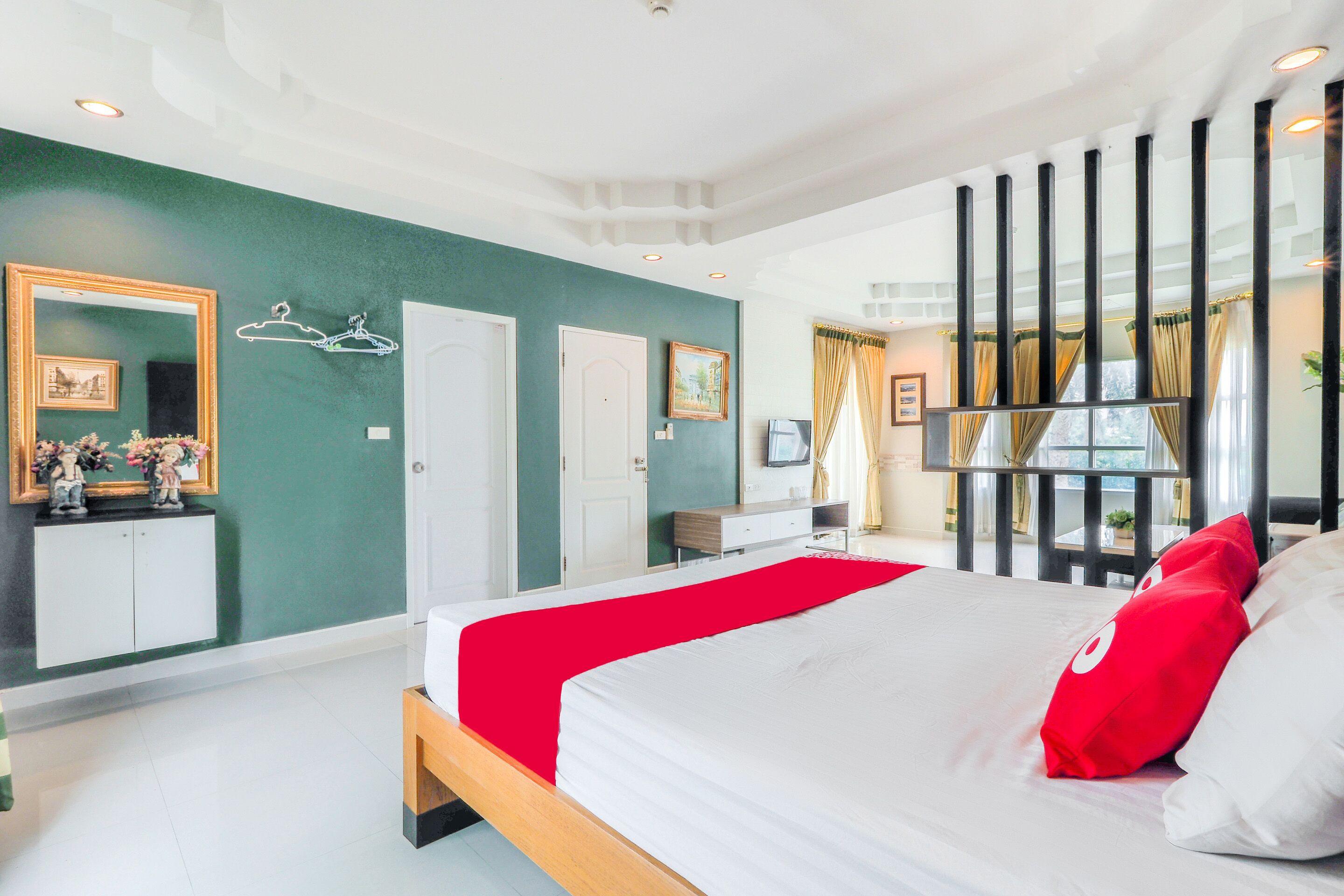 A modern hotel room with a large bed, a wardrobe, a vanity, and a window with curtains.