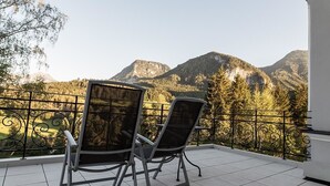 Un balcón con dos sillas y vistas a las montañas.