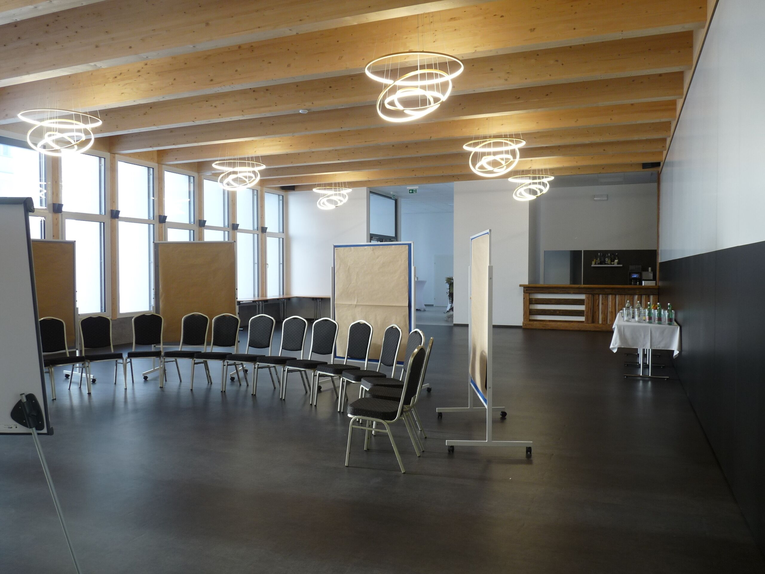Un salón de conferencias con una mesa redonda, sillas y una recepción con mantel blanco.