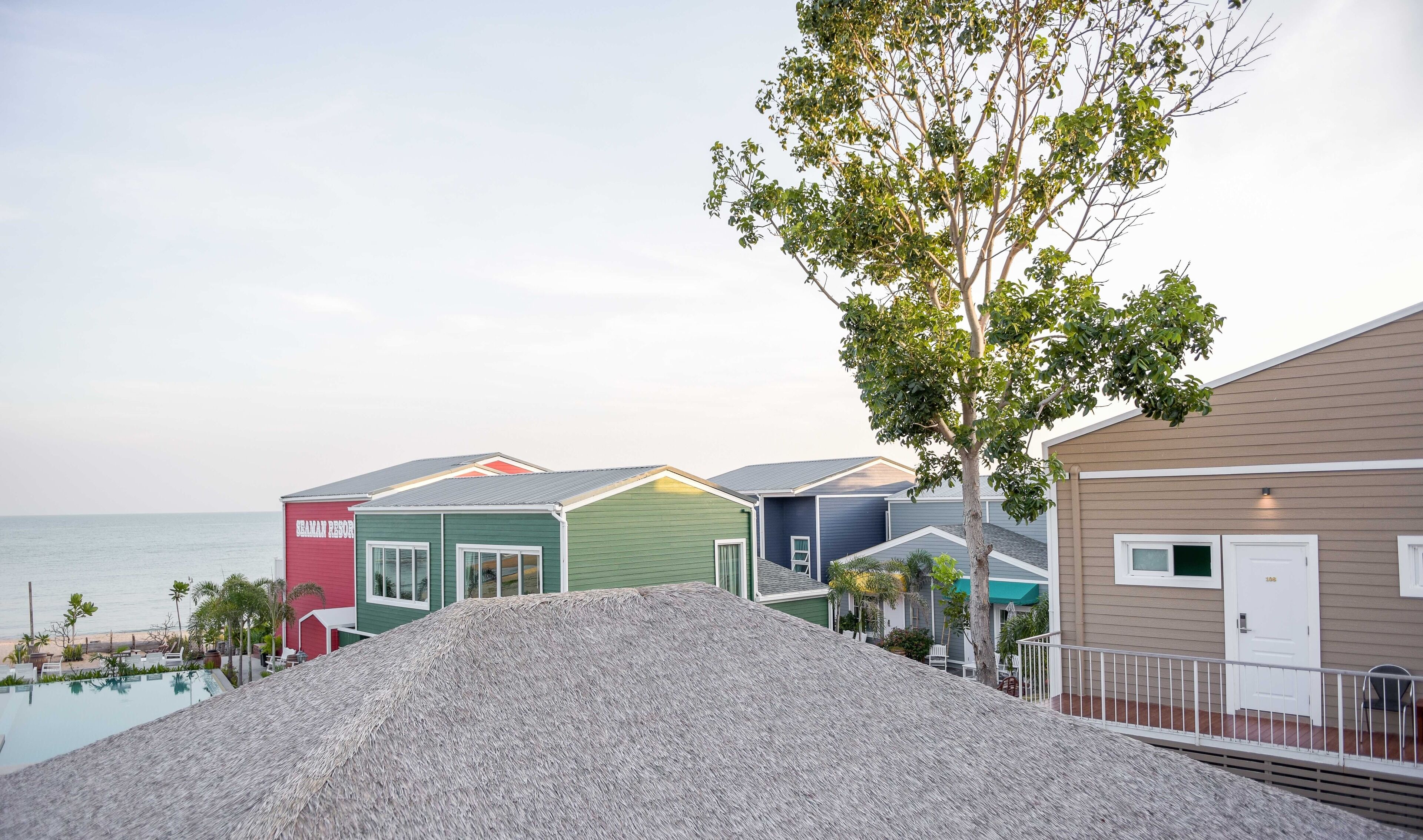 A row of colorful beach houses with a pool in the foreground.