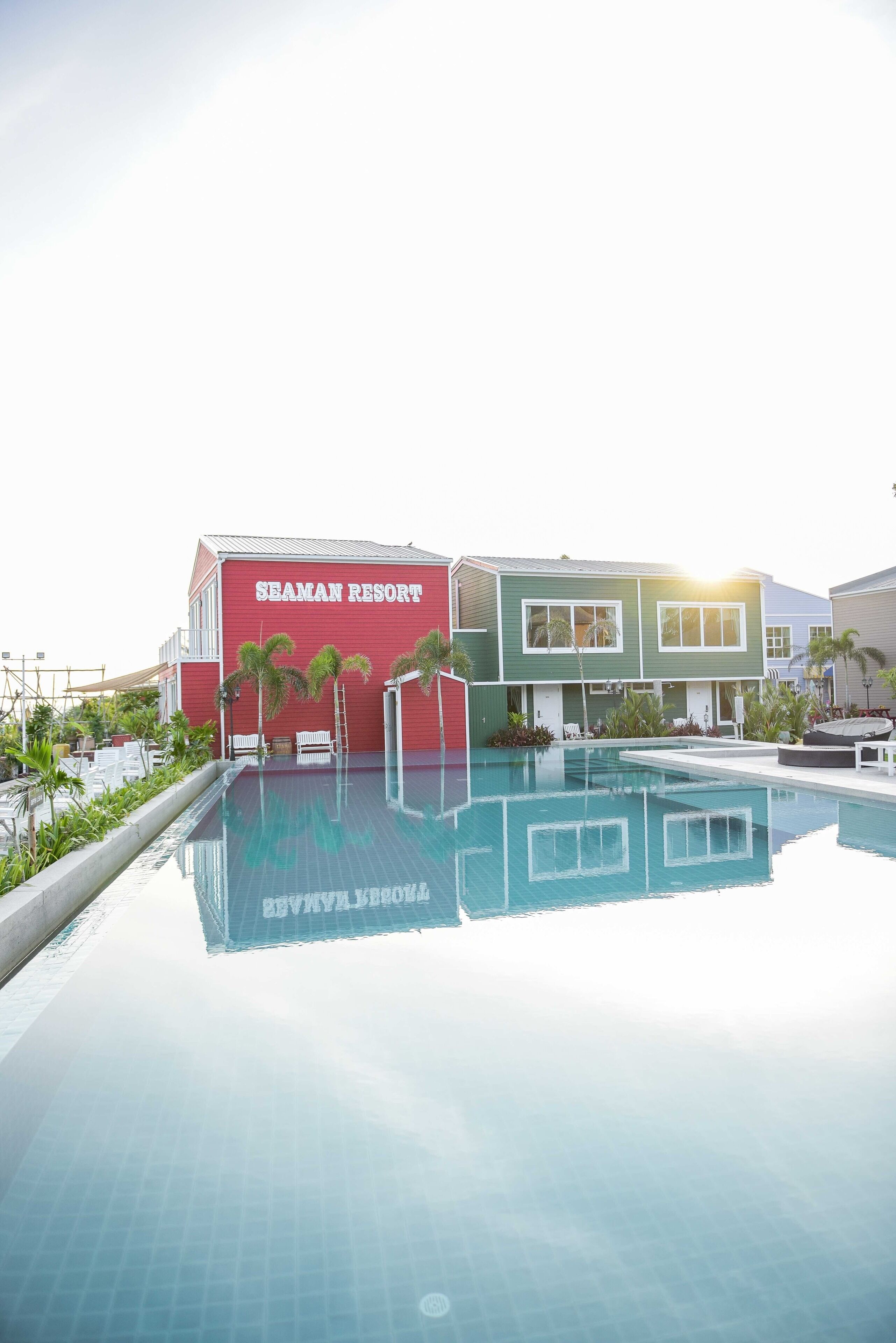 Une piscine au Seaman Resort, offrant une vue dégagée sur le nom de l’établissement, qui est inscrit sur le bâtiment.