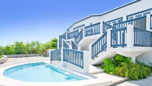 A modern house with a swimming pool, a staircase with blue railings, and a garden area. - Beautiful, Spacious two bedroom Ocean View Villa (providenciales)