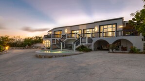 A modern two-story building with a swimming pool, multiple balconies, and a well-lit entrance. - Beautiful, Spacious two bedroom Ocean View Villa (providenciales)