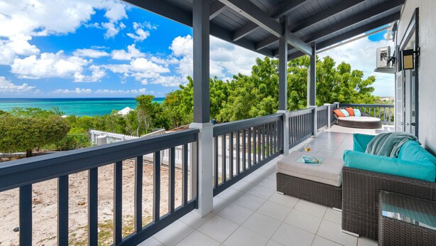 A covered outdoor seating area with a view of the ocean and beach. - Beautiful, Spacious two bedroom Ocean View Villa (providenciales)