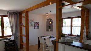 A dining area with a table, chairs, and a hanging light fixture. - Vacation apartment Schwarzwaldliebe near Freiburg, terrace (Bollschweil)