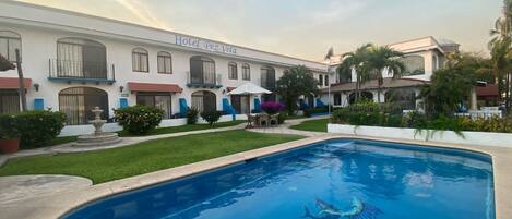 Un hotel con piscina y fuente.