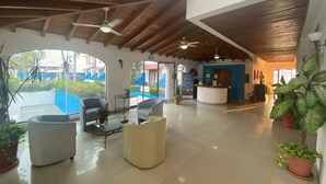 A spacious lobby with a reception desk, seating area, and large windows offering views of the outside. - Hotel Pez Vela Manzanillo (Manzanillo)