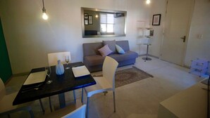 A modern living room with a dining table, a sofa, and a large mirror. - 50% of Monthly 35% weekly  (Versalles)