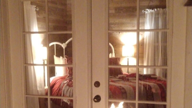 A room with a bed, a nightstand, and a lamp.
