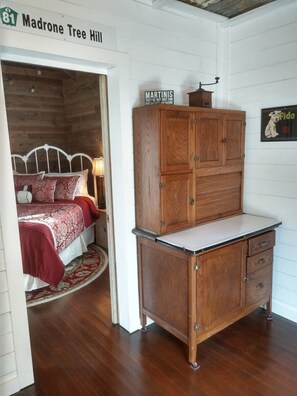 A room with a bed, a wooden cabinet, and a sign indicating 'Madrone Tree Hill'.