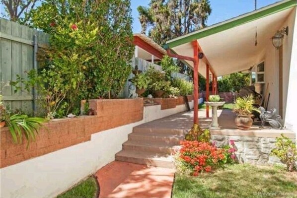 Enjoy the serene garden and covered porch area, perfect for relaxing.