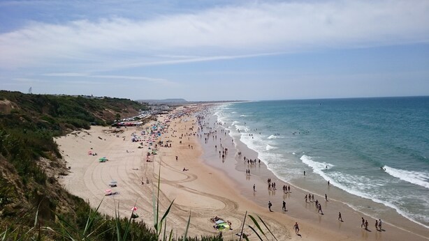 A beach with people, umbrellas, and a clear sky. - Apartment 100 meters from the promenade and beach. Incredible rooftop views. (Conil de la Frontera)