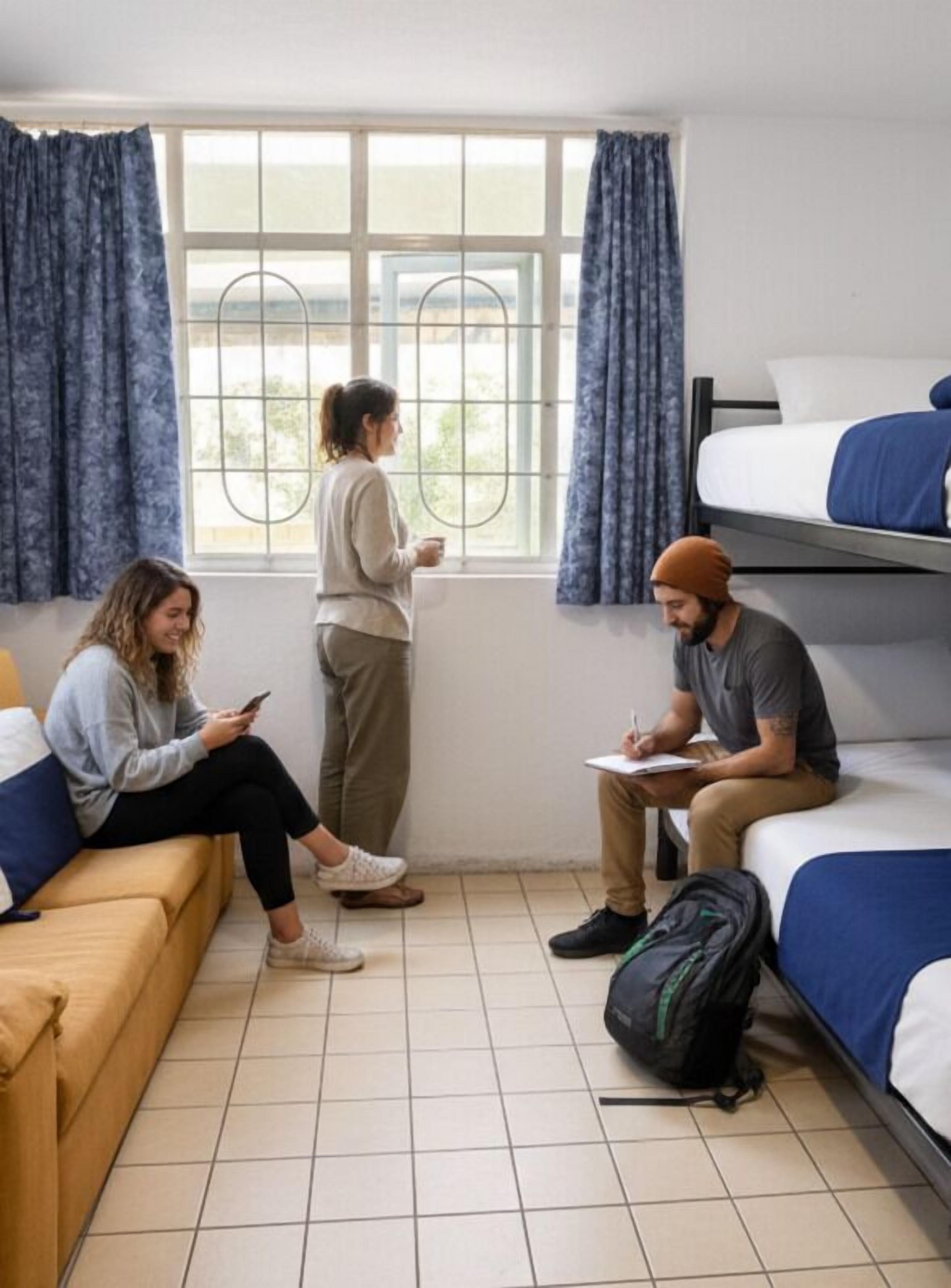 Un dormitorio con literas, una ventana con cortinas y piso de baldosas.