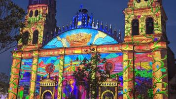 A historic building with two towers and a colorful light display.