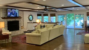 Uma sala de estar ampla com lareira, sofá modular e televisão.