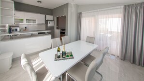 A modern kitchen with white cabinets, a built-in oven, and a microwave. - Apartments Anita - Luxury Three-Bedroom Apartment with Terrace (Stobrec)