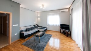A modern living room with a sectional sofa, a coffee table, and a flat-screen TV. - Apartments Anita - Luxury Three-Bedroom Apartment with Terrace (Stobrec)