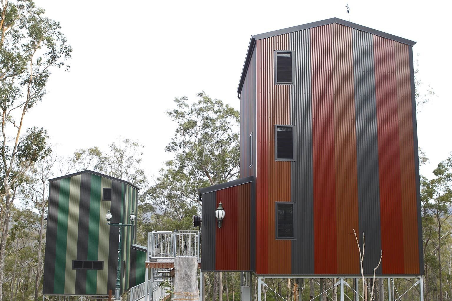 A modern building with a unique striped facade, a smaller adjacent structure, and a metal staircase leading to a platform.