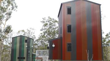 A modern building with a unique striped facade, a smaller adjacent structure, and a metal staircase leading to a platform.