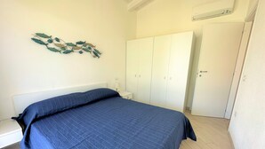 Un dormitorio con cama, armario y un adorno en la pared.