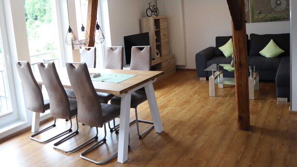 A modern living space with a dining area, a sofa, and a bike. - Vacation apartment Eder-Ufer 1 - Holiday apartments Eder-Ufer (Edertal)