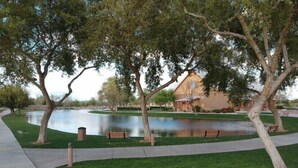 A park with a pond, benches, and a building in the background. - Modern Remodel + Amenities Galore! (Gilbert)