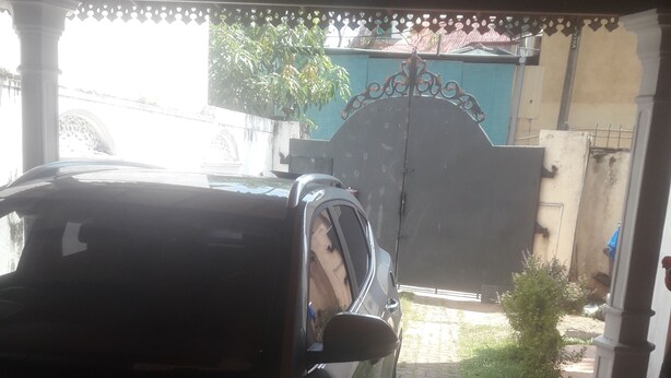 A car parked under a covered area with a tiled floor. - House with 4 beds and 2 attached bathroom.  (Wattala)